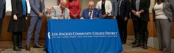 CSUDH President Thomas A. Parham (seated, left) and LACCD Chancellor Francisco C. Rodriguez (seated, right) signing the Memorandum of Understanding.